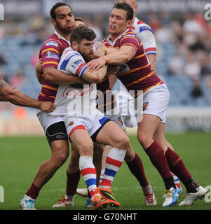 Wakefield Wildcats'Jarrod Sammut wird von Huddersfield Giants' Leroy Cudjoe (links) und Shaun Lunt während des ersten Utility Super League Spiels im John Smith's Stadium, Huddersfield, angegangen. Stockfoto