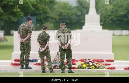 Britische Soldaten betrachten Kränze, die vor dem 60. Jahrestag des D-Day an diesem Wochenende auf dem Friedhof der Kriegsgräber des Commonwealth von Bayeux niedergelegt wurden. Stockfoto