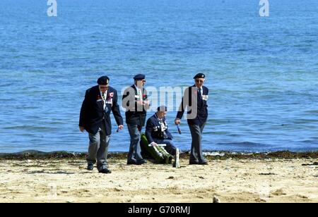 Veteranen wandern auf dem Sand des Juno Beach in der Normandie, nordwestlich von Farnce. Bei einer Zeremonie mit Blick auf den Strand von Courseulles-sur-Mer, einer von fünf Landungen am D-Day, wurde Königin Elizabeth II. Von dem kanadischen Premierminister Paul Martin und der Generalgouverneurin Adrienne Clarkson begleitet, um den 14,000 kanadischen Truppen, die am 6. Juni gemeinsam mit ihren britischen und amerikanischen Kameraden gekämpft haben, Tribut zu zollen. 1944. Stockfoto