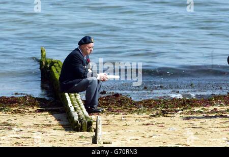 Ein Veteran sitzt am Strand von Juno Beach in der Normandie, im Nordwesten von Farnce. Bei einer Zeremonie mit Blick auf den Strand von Courseulles-sur-Mer, einer von fünf Landungen am D-Day, wurde Königin Elizabeth II. Von dem kanadischen Premierminister Paul Martin und der Generalgouverneurin Adrienne Clarkson begleitet, um den 14,000 kanadischen Truppen, die am 6. Juni gemeinsam mit ihren britischen und amerikanischen Kameraden gekämpft haben, Tribut zu zollen. 1944. Stockfoto