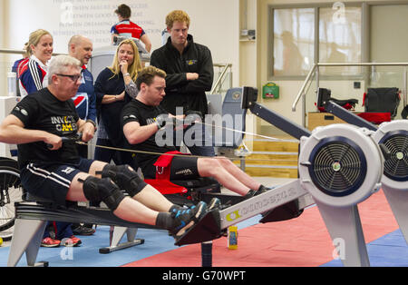 Prinz Harry sieht zu, wie Lance Corporal Kevin Pollard (links) und Veteran Jonathon Le Galloudec während eines Besuchs im Help for Heroes Fitnessstudio im Tedworth House in Tidworth, Wiltshire, auf Rudergeräten antreten. Stockfoto