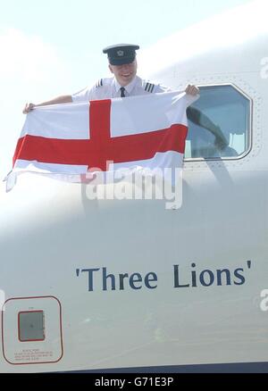 Als die englische Fußballmannschaft am Flughafen Luton an Bord ihres Flugzeugs ging, um für die Euro 2004 nach Portugal zu fliegen, fliegt der finnische Erstoffizier Ilkka Tahvanainen unter die Flagge. Stockfoto