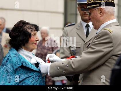 Die 99-jährige Andree Peele erhält die Legion d'Honneur - Frankreichs höchste Auszeichnung - von ihrem Bruder, General Maurice Virot, pensioniert, neben der Statue von General de Gaulle in Carlton Gardens, London. Andree Peel erhielt den Preis für ihre Arbeit mit dem französischen Widerstand, wo sie dutzende RAF- und amerikanische Bomberpiloten unterstützte, die während des Zweiten Weltkriegs über Frankreich abstürzte. Frau Peel, die in Long Ashton in der Nähe von Bristol lebt, hat bereits eine Reihe von Auszeichnungen für ihre Rolle in dem Krieg erhalten, darunter die King's Commendation for Brave Conduct, die sie von King George erhielt, Stockfoto