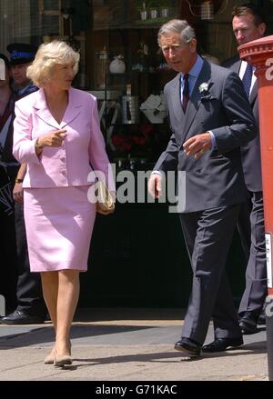 Der Prinz von Wales und seine Partnerin Camilla Parker-Bowles grüßen die Mitglieder der Öffentlichkeit vor dem Merchant's House in Marlborough in Wiltshire, wo sie dem Prinzen zwei "Bobby Vans" zeigte, ein Verbrechensverhütungsschema, dessen Treuhänder sie ist. Stockfoto