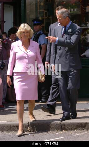 Der Prinz von Wales und seine Partnerin Camilla Parker-Bowles grüßen die Mitglieder der Öffentlichkeit vor dem Merchant's House in Marlborough in Wiltshire, wo sie dem Prinzen zwei "Bobby Vans" zeigte, ein Verbrechensverhütungsschema, dessen Treuhänder sie ist. Stockfoto