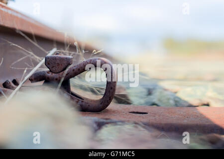 Nahaufnahme von rostigen Eisenbahnstrecken überqueren eine alte Holzbrücke an einem nebligen Morgen Stockfoto