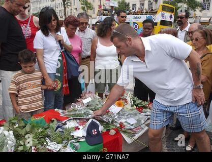 Fußballfans, Brunner und Trauernde legen Blumen an einem Schrein auf dem Rossio-Platz in Lissabon für Stephen Smith, 28, aus Wolverhampton, der während der Feierlichkeiten nach dem Euro-2004-Sieg über Kroatien erstochen wurde. Ukrainische Taschendieb Vadym Abramov, 31, wurde verhaftet und erschien heute vor Gericht. Die Tragödie ereignete sich um 3.30 Uhr in der Rua Augusta, gleich neben dem Rossio-Hauptplatz der portugiesischen Hauptstadt. Stockfoto