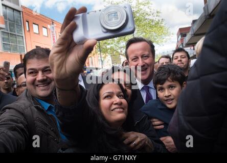 Premierminister David Cameron tritt zu einem „Selfie“ ein, als er im Stadtzentrum von Harrow mit den Einheimischen zusammentreffen wird, während er mit dem Bürgermeister von London, Boris Johnson, auf den Wahlkampfweg ging. Stockfoto