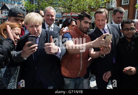 Der Bürgermeister von London Boris Johnson und Premierminister David Cameron und posieren für „Selfies“, während sie die Einheimischen im Stadtzentrum von Harrow treffen, während er mit dem Bürgermeister von London Boris Johnson auf den Wahlkampfweg ging. Stockfoto