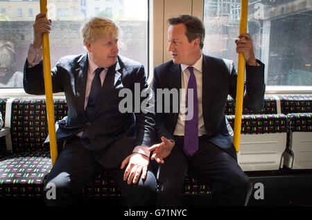 Der Bürgermeister von London, Boris Johnson, und Premierminister David Cameron sitzen in einem U-Bahn-Zug auf dem Weg nach Westminster, nachdem sie das Harrow Skills Center besucht und lokale Einkäufer im Stadtzentrum von Harrow treffen, während sie gemeinsam auf den Wahlkampfweg gingen. Stockfoto