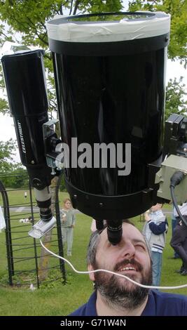 David Moore, Vorsitzender von Astronomy Ireland, aus Dublin, schaut durch ein Teleskop, um den Planeten Venus, der in einem seltenen Ereignis im astronomischen Kalender über das Gesicht der Sonne vorbeizieht, im Phoenix Park in Dublin, Irland, zu sehen, während seine Schwester Aisling, 6, auf ihn blickt. Es war der erste Venustransit seit 1882 und das letzte Mal, dass er aus Großbritannien aus 1283 beobachtet werden konnte - lange vor der Erfindung des Teleskops. Der nächste planetarische Nachbar der Erde erschien als schwarze Scheibe 30 mal kleiner als der Durchmesser der Sonne und bewegte sich im Laufe von sechs Stunden langsam von links nach rechts. Stockfoto