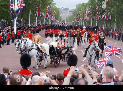 Die britische Königin Elizabeth II. Sitzt mit dem Herzog von Edinburgh in einer offenen Kutsche während der Trooping the Color Zeremonie entlang der Mall im Zentrum von London. Stockfoto