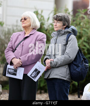 Mitglieder der Öffentlichkeit schauen zu, während sie eine große Leinwand hören und sehen, wie der Trauerdienst der Autorin Sue Townsend vor der De Montford Hall in Leicester übertragen wird. Stockfoto