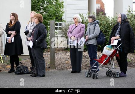 Mitglieder der Öffentlichkeit schauen zu, während sie eine große Leinwand hören und sehen, wie der Trauerdienst der Autorin Sue Townsend vor der De Montford Hall in Leicester übertragen wird. Stockfoto