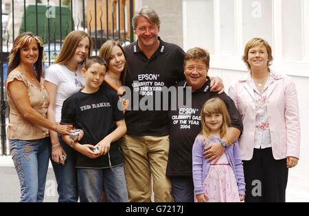 Bodentruppen-Moderator Tommy Walsh und Heart FM DJ's Jono Coleman mit (links-rechts) der Frau von Tommy, Marie Walsh und ihren Kindern Natalie, 16, John Joe, 10, und Charlotte, 13, und Colemans Frau Margo und ihre Tochter Emily, 7, während einer Fotocolalle, um den Gewinn des Epsom Celebrity Dad of the Year 2004 vor dem Grovesnor House Hotel im Zentrum von London zu feiern. Stockfoto