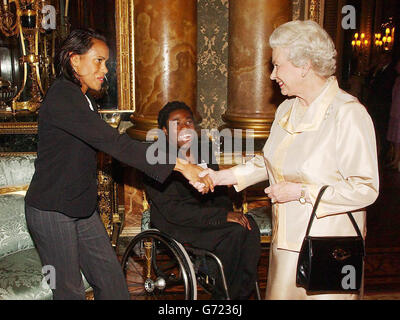 Die britische Königin Elizabeth II trifft auf die australische Athletin Cathy Freeman (links), die von der para-Olympic-Basketballspielerin Ade Adepitan bei einem Empfang im Buckingham Palace für die an der Bewerbung Londons für die Olympischen Spiele 2012 beteiligten Personen beobachtet wird. Eine Sprecherin aus London 2012 sagte, dass der Empfang organisiert wurde, um den Beteiligten an der Olympischen Bewerbung in London 2012 zu danken und dass die Veranstaltung auch dem Team und seinen Unterstützern und Botschaftern viel Glück für den Rest der Kampagne wünschen soll. Stockfoto