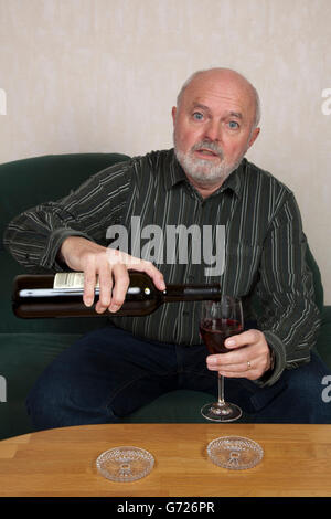 Senior woman gießt Wein Stockfoto