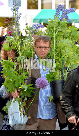 Ein Mann trägt eine Pflanze, die gekauft wurde, weil die Exponate am Ende der RHS Chelsea Flower Show im Royal Hospital in Chelsea, London, verkauft werden. DRÜCKEN SIE VERBANDSFOTO. Bilddatum: Samstag, 24. Mai 2014. Das Foto sollte lauten: John Stillwell/PA Wire Stockfoto