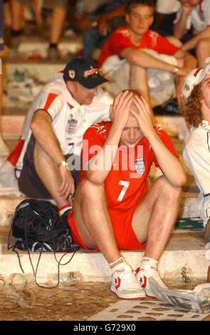 England-Fans zeigen ihre Dejektion, nachdem sie das Spiel der Euro 2004 gegen Frankreich auf dem großen Sreen im Parque das Nacoes, Lissabon, Portugal, gesehen haben. Frankreich gewann 2:1. Stockfoto