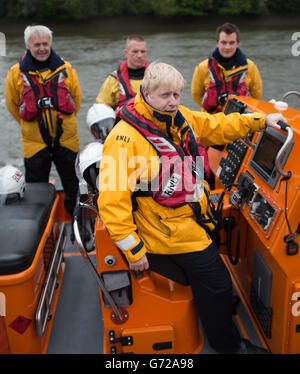 Der Bürgermeister von London Boris Johnson trifft RNLI Lifeboat Crews an der Chiswick Lifeboat Station im Westen Londons, wo er während der RNLI-Spendenwoche auch das Steuer eines ihrer Boote auf der Themse übernahm. Stockfoto