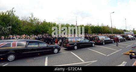 Trauernde erweisen sich als Leichenwagen, die die Särge von fünf Servicemitarbeitern tragen, die bei einem Hubschrauberabsturz in Afghanistan ums Leben kamen, und passieren den Memorial Garden in Carterton, Oxfordshire. Stockfoto