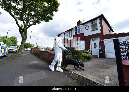 Ein forensischer Offizier mit einem Hund vor einem Haus in der Hollywell Road, North Shields, das eines von zwei 100 Meilen entfernten Häusern ist, wird von der Polizei durchsucht, nachdem ein Mann wegen des Verdachts, die vermisste Universitätskochin Claudia Lawrence ermordet zu haben, verhaftet wurde. Stockfoto