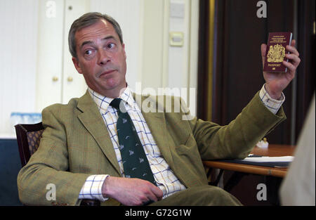 Der UKIP-Führer Nigel Farage hält seinen Pass hoch, als er von der Pressevereinigung in Belfast während eines eintägigen Besuchs in der Provinz interviewt wird, wo er auch die Kandidaten seiner Partei bei den bevorstehenden Kommunalwahlen getroffen hat. Stockfoto