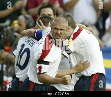 Der englische Michael Owen (links) wird von Teamkollegen nach dem Tor zum Eröffnungstreffer gegen Portugal gratuliert, wie Kapitän David Beckham beim Viertelfinalspiel der Euro 2004 im Estadio de Luz in Lissabon, Portugal, ansieht. Stockfoto