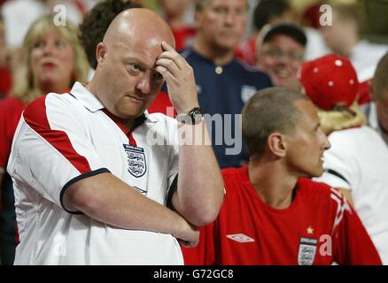 England-Fans zeigen ihre Niedergeschlagenheit nach dem plötzlichen Todesurteil im Viertelfinale der Euro 2004 gegen Portugal im Estadio da Luz in Lissabon, Portugal. England verlor gegen Portugal 6-5 auf Strafen, nachdem das Spiel in einem Unentschieden von 2-2 nach Verlängerung endete. Stockfoto