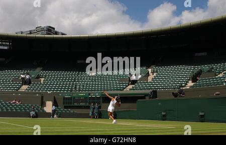 Jennifer Capriati aus den USA dient Nathalie Dechy aus Frankreich in einem leeren Platz Nummer eins bei den Lawn Tennis Championships in Wimbledon, London. Das Spiel wurde am 'Volkssonntag' abgehalten, weil es zwei Tage ohne Spiel früher in der Woche durch Regen verursacht wurde. Es ist erst das dritte Mal, dass dies in der Geschichte des Turniers passiert ist und Tennisfans strömten zum Center Court, um den Titelverteidiger Roger Federer in Aktion und später Tim Henman zu sehen, aber es versäumte, auf dem benachbarten Court One Platz zu nehmen. KEIN HANDY. Stockfoto