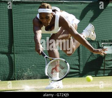 Kreidestaub bläst auf, als die Titelverteidigerin Serena Williams aus den USA im Halbfinale des Lawn Tennis Championships in Wimbledon, London, IM Halbfinale des Ladies-Singles-Turniers zu den Lawn Tennis Championships nach Frankreich zurückkehrt. Stockfoto