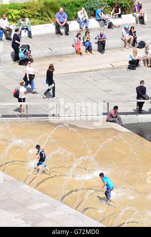 Kinder kühlen sich in den Springbrunnen des Marktplatzes in Nottingham ab, wenn das warme Wetter anhält. Stockfoto