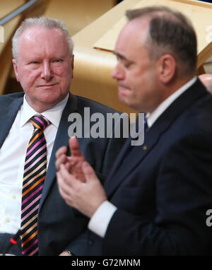 Der schottische Gesundheitsminister Alex Neil (links) hört sich den schottischen Premierminister Alex Salmond während der Fragestunde der ersten Minister im schottischen Parlament in Edinburgh an. Stockfoto