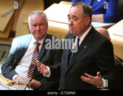 Der schottische Gesundheitsminister Alex Neil (links) hört sich den schottischen Premierminister Alex Salmond während der Fragestunde der ersten Minister im schottischen Parlament in Edinburgh an. Stockfoto