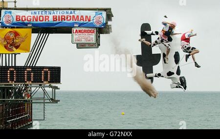 Lawrence Harrison und Bob Dix fallen vom Pier in den Ärmelkanal zusammen mit ihrer Kreation, einer Skateboarding-Kuh, während des Arun International Bognor Birdman 2004 Events in Bognor Regis, West Sussex. Stockfoto