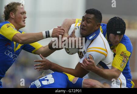 Der Leeds Rhinos' Ali Lauititi wird von Warrington Wolves' Ben Westwood (links) und Mike Wainwright (rechts) während des Tetley's Super League Spiels im Halliwell Jones Stadium, Warrington, angegangen. ** Stockfoto