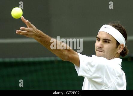 Titelverteidiger Roger Federer aus der Schweiz steht Ivo Karlovic aus Kroatien bei den Lawn Tennis Championships in Wimbledon, London, zur Verfügung. KEIN HANDY. Stockfoto