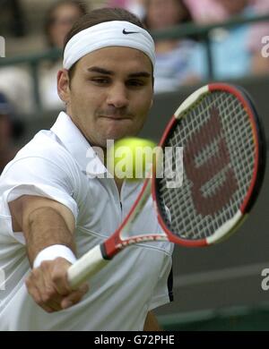 Titelverteidiger Roger Federer aus der Schweiz im Einsatz gegen Ivo Karlovic aus Kroatien bei den Lawn Tennis Championships in Wimbledon, London. KEIN HANDY. Stockfoto