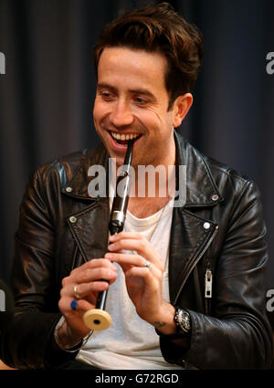 Radio 1 Frühstücksshow-Moderator Nick Grimshaw wird im National Piping Center in Glasgow von Finlay MacDonald vor dem Radio 1 Big Weekend das Spielen der Dudelsäcke beigebracht. Stockfoto