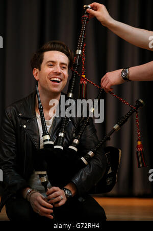 Radio 1 Frühstücksshow-Moderator Nick Grimshaw wird im National Piping Center in Glasgow von Finlay MacDonald vor dem Radio 1 Big Weekend das Spielen der Dudelsäcke beigebracht. Stockfoto