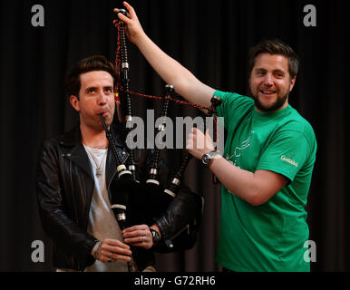 Radio 1 Frühstücksshow-Moderator Nick Grimshaw wird im National Piping Center in Glasgow von Finlay MacDonald vor dem Radio 1 Big Weekend das Spielen der Dudelsäcke beigebracht. Stockfoto