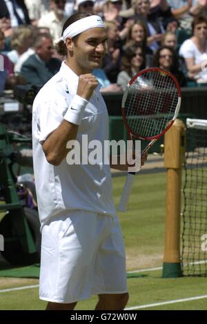 Titelverteidiger Roger Federer aus der Schweiz hebt seinen Schläger nach seinem Sieg über Sebastien Grosjean aus Frankreich im Halbfinale des Herren-Singles-Turniers bei den Lawn Tennis Championships in Wimbledon. Federer gewann das Spiel, das vom Vortag in geraden Sätzen 6:2/6:3/7:6 verschoben wurde. KEIN HANDY. Stockfoto