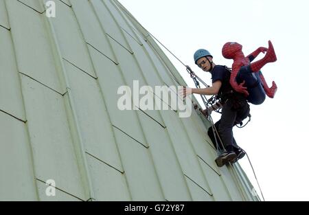 Der Londoner Abseiler Dennis Lees positioniert im Rahmen der Eröffnung von Madame Tussauds neuer Attraktion Spiderman am 14. Juli 2004 ein Modell von Spiderman auf der Kuppel des Tussauds Planetariums in London. Stockfoto