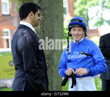 Jockey Kieren Fallon trägt die blaue Seide Godolphin, während er mit Trainer Saeed bin Suroor während des Sandy Lane Stakes Tages auf der Haydock Park Rennbahn spricht. Stockfoto