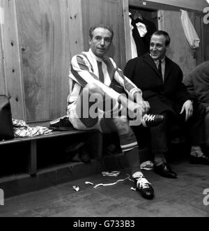 Stanley Matthews, 50 Jahre alt, als der erste Fußballritter spielte, schnürt seine Stiefel in der Garderobe von Stoke und wird vor dem Spiel gegen Fulham von Teamkollege Maurice Setters beobachtet. Dies war Stanley's Comeback-Spiel und er half Stoke zu einem Sieg von 3-1, indem er ein großes Tor für den mittleren Stürmer Ritchie aufstellte. Danach sagte er: "Es war großartig, wieder zurück zu sein." Stockfoto