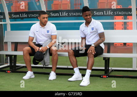 Im Sun Life Stadium, Miami, USA, sitzen der schwebende englische Raheem Sterling (rechts) und der verletzte Teamkollege Alex Oxlade Chamberlain im Dugout vor dem International Friendly. DRÜCKEN Sie VERBANDSFOTO. Bilddatum: Samstag, 7. Juni 2014. Siehe PA Geschichte FUSSBALL England. Bildnachweis sollte lauten: Mike Egerton/PA Wire. Stockfoto