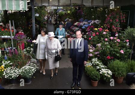 Königin Elizabeth II. Mit dem französischen Präsidenten Francois Hollande und der Bürgermeisterin von Paris Anne Hidalgo, während sie auf dem Blumenmarkt nach Marche aux Fleurs - reine Elizabeth II. Geht, in der Nähe der Kathedrale Notre Dame in Paris, während ihr dreitägiger Staatsbesuch in Frankreich zu Ende geht Stockfoto