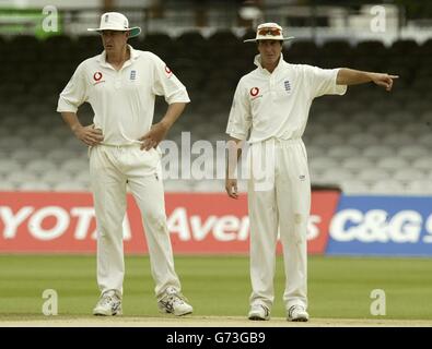 Der englische Kapitän Michael Vaughan (rechts) stellt seine Fielder für Spin Bowler Ashley Giles am letzten Tag des ersten npower-Testspieles gegen die Westindischen Inseln bei Lord's ein. Stockfoto