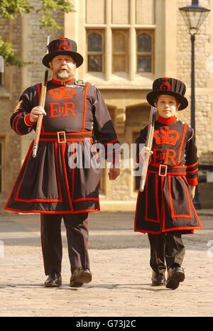 Vahan Salorian, 11, aus Barnoldswick in Lancashire, marschiert auf dem Gelände des Tower of London zusammen mit seinem Führer für den Tag Yeoman-Gefängniswärter John Keohane. Der glückliche Junge gewann einen Wettbewerb, um Yeoman Warder of the Tower in einer der beliebtesten Touristenattraktionen der Hauptstadt zu werden. Stockfoto