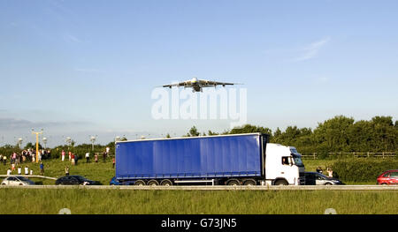 Das größte Flugzeug der Welt, die Antonov an-225 Mriya, fliegt über die A453 und landet auf dem East Midlands Airport, Castle Donington, Derby. Stockfoto